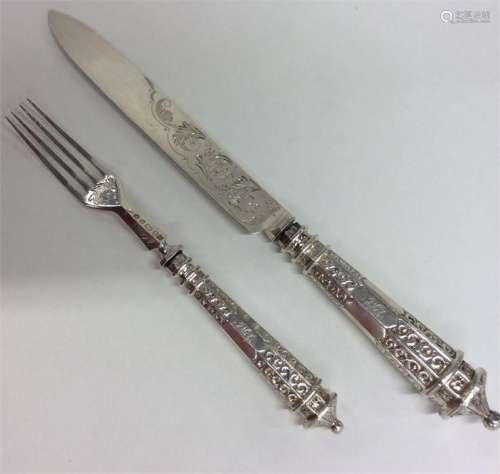 A heavy pair of silver servers with tapering handl