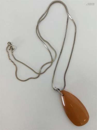 An amber teardrop pendant on silver chain. Approx.