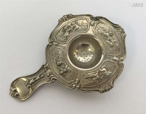 A Continental silver tea strainer heavily decorate