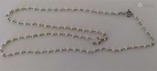 A fine seed pearl and platinum chain with ring cla