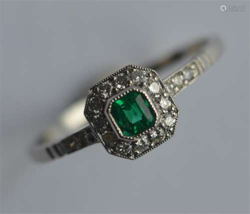 An attractive platinum, emerald and diamond cluste
