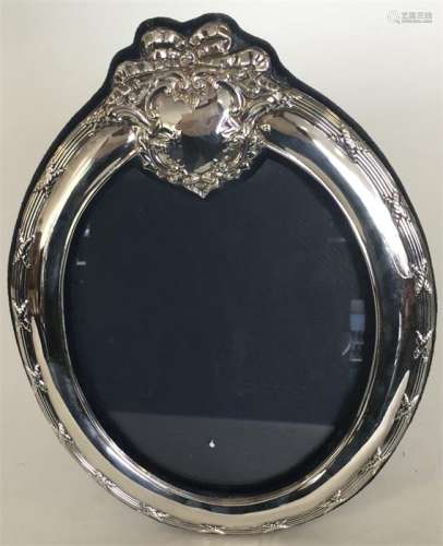 A large modern silver oval picture frame with velv