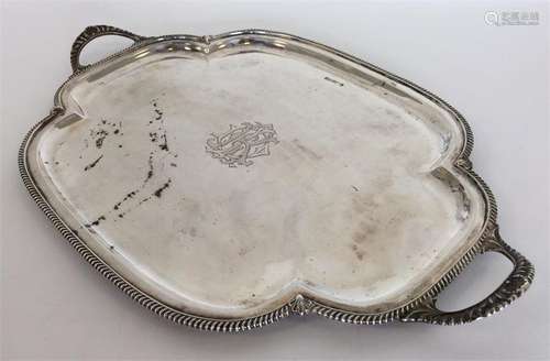 A silver tea tray with gadroon rim and canted corn