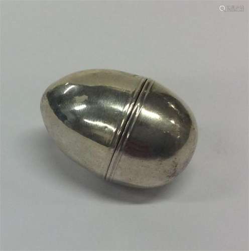 An egg-shaped silver nutmeg grater of plain design