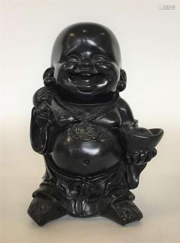 A carved wooden figure of Buddha carrying a loaded