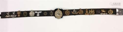 A good leather belt containing cap badges and Mili