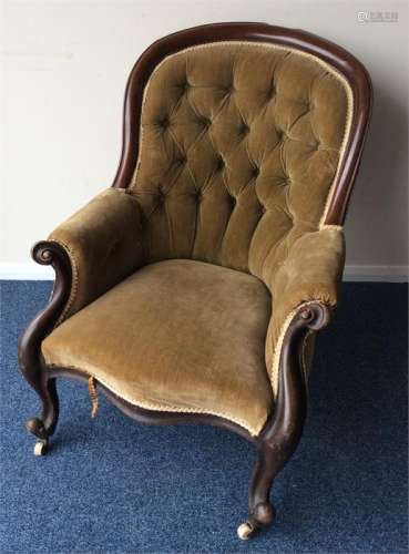 A Victorian button-back armchair on scroll support