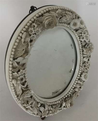 A miniature oval mirror decorated with flowers and