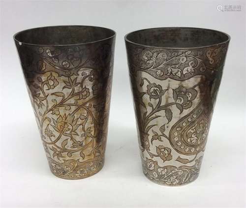 A pair of heavy Indian goblets decorated with flow