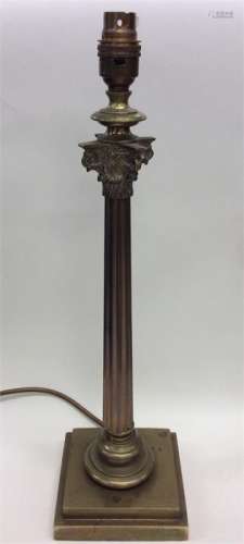A brass Corinthian column lamp of typical design.