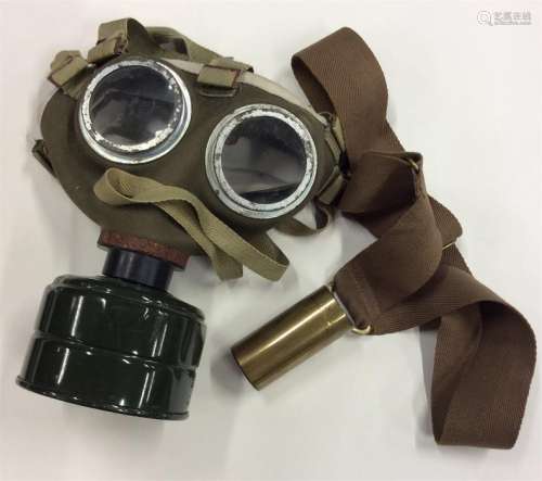 An old World War II gas mask together with a brass