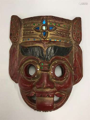 A red lacquered tribal mask decorated in bright co