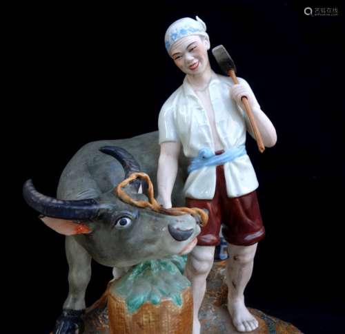 A PORCELAIN STATUE OF A MAN AND A COW