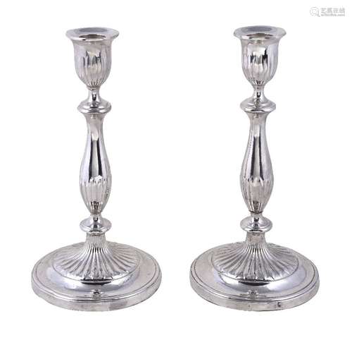 A pair of English circular candlesticks, apparently unmarked, circa 1790, with part fluted capitals,