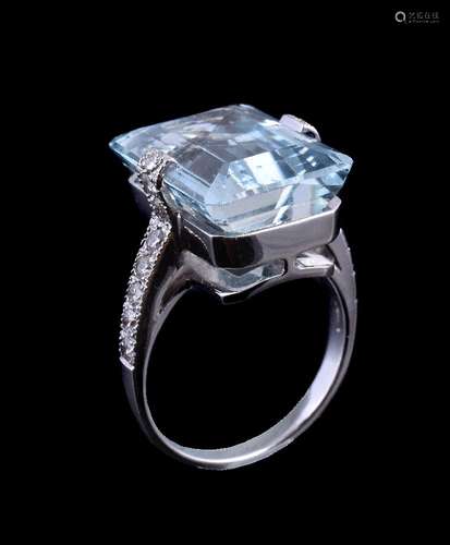 An aquamarine and diamond ring, the central rectangular cut aquamarine in a claw setting, between