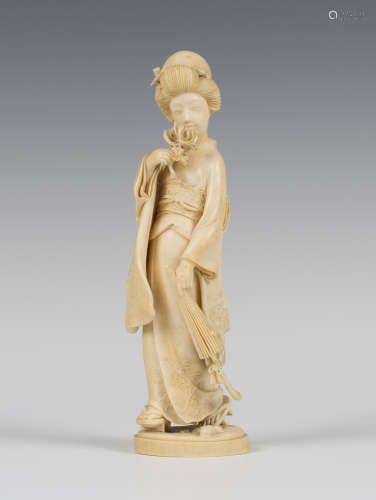 A Japanese carved ivory okimono figure of a maiden, Meiji period, finely modelled holding a peony to