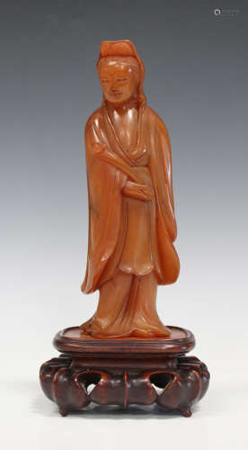 A Chinese carved amber figure of Guanyin, early 20th century, modelled standing and holding a ruyi