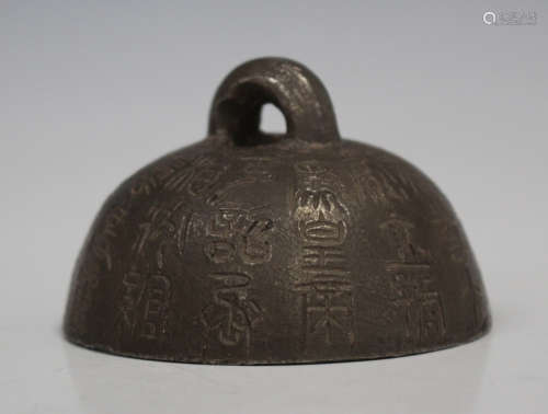 A Chinese cast iron weight of hemispherical form with loop surmount, decorated with lines of