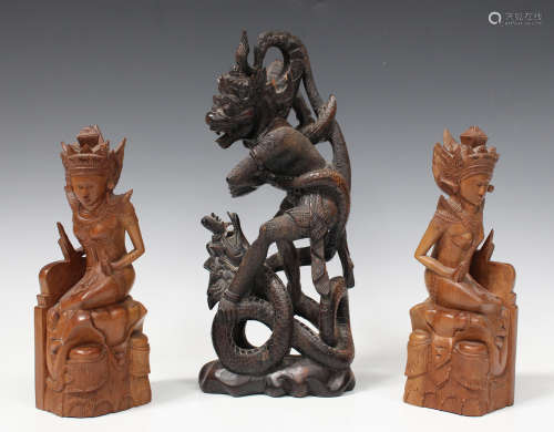 A Balinese/Javanese carved hardwood figure group, 20th century, modelled as a deity and dragon,