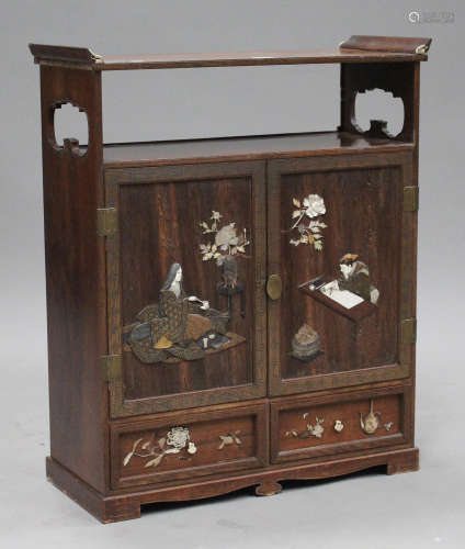 A Japanese inlaid wooden cabinet, Meiji period, the shelf top above a pair of cupboard doors, inlaid