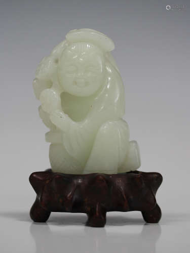 A Chinese pale celadon jade carving, probably 20th century, modelled as a boy kneeling beside a