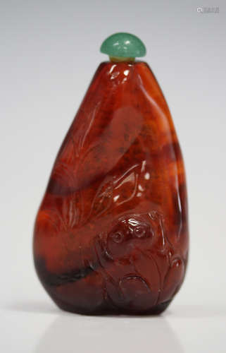 A Chinese amber snuff bottle, probably late Qing dynasty, carved in low relief with a fish and toad,
