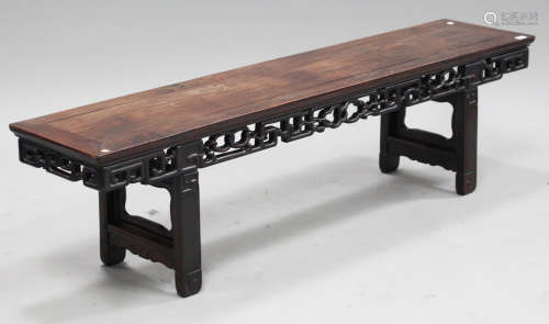 A Chinese hardwood low altar table, late Qing dynasty, the rectangular panelled top above a carved