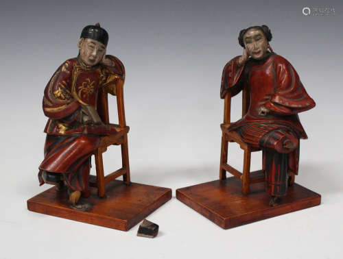 A pair of Chinese carved and lacquered wood figures of a man and woman, late Qing dynasty, each