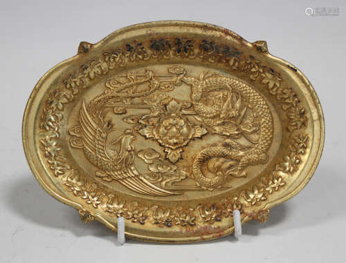 A Chinese gilt bronze shaped oval dish, the centre cast in relief with opposing dragon and phoenix