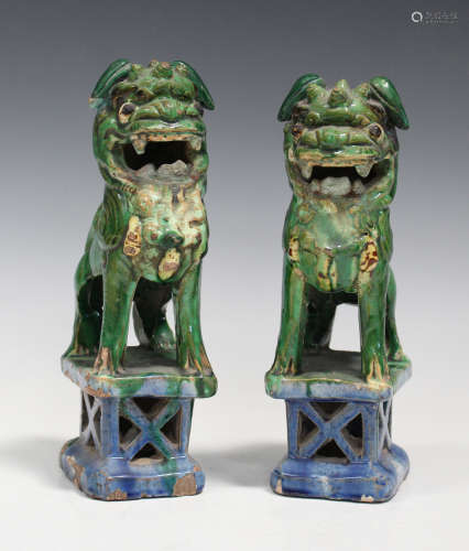 A pair of Southern Chinese green glazed earthenware figures of Buddhistic lions, late Qing