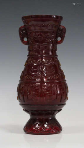 A Chinese Peking red glass vase, 20th century, the baluster body decorated in relief with bands of