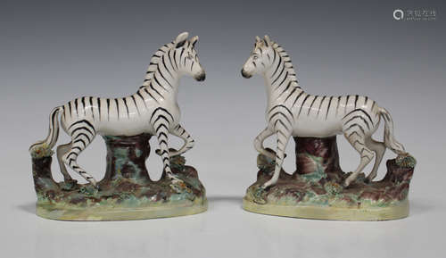 A pair of Staffordshire pottery models of zebra, late 19th century, each modelled standing on a