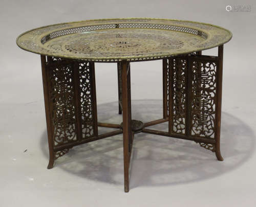 A Chinese brass and hardwood table, early/mid-20th century, the brass circular top pierced and