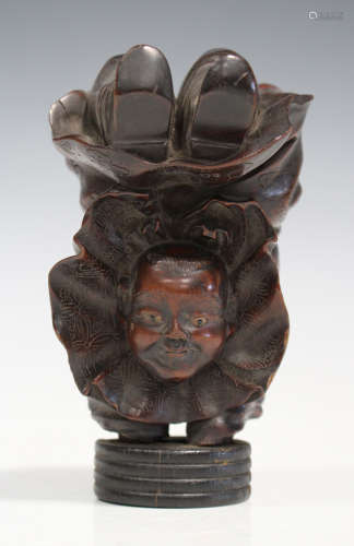 A Japanese carved wood figure of an acrobat boy, Meiji period, modelled performing a handstand,