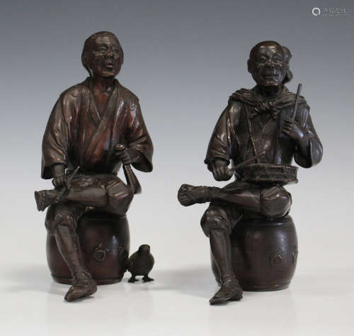 A pair of Japanese brown patinated bronze figures, Meiji/Taisho period, each modelled seated on a