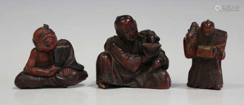 A Japanese carved wood okimono, Meiji period, modelled as a seated gentleman with minnogame