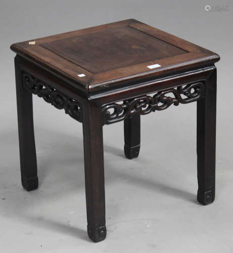 A Chinese hardwood low stand, late Qing dynasty, the square panelled top above a carved and