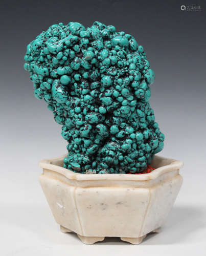 A Chinese simulated turquoise ornament of irregular upright form, mounted within an alabaster