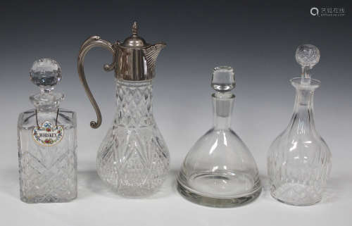 A clear glass claret jug with plated mounts, height 30cm, together with three decanters and three