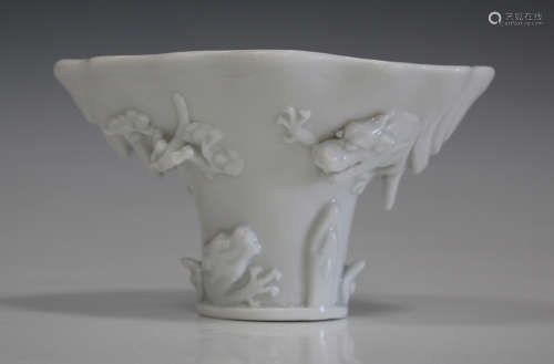 A Chinese blanc-de-Chine porcelain libation cup, Qing dynasty, of traditional horn form, moulded and