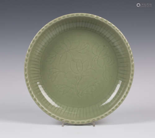 A Chinese celadon circular dish, probably Ming dynasty, heavily potted and carved to the centre with