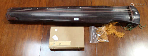 A Chinese brown lacquered wood guqin, late 20th century, the tapered soundbox with bowed top,
