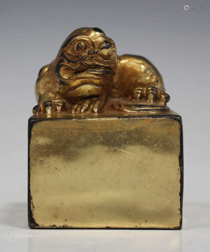 A Chinese gilt bronze seal, the cube plinth surmounted with a seated Buddhistic lion cub, six