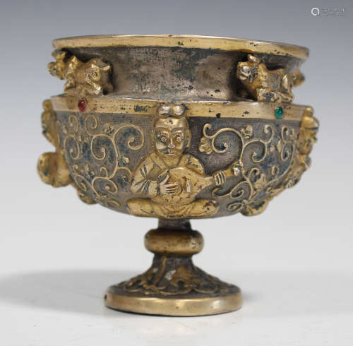 A Chinese gilt and silvered bronze cup, modern, cast in relief with a band of seated musicians