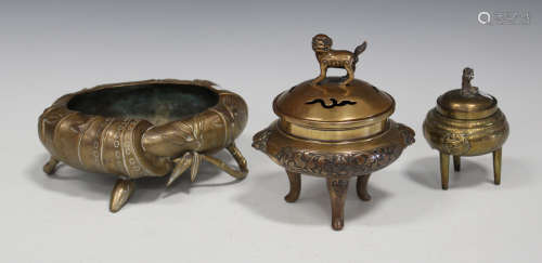 A Chinese polished bronze tripod censer, late Qing dynasty, the pierced cover with kylin finial, the