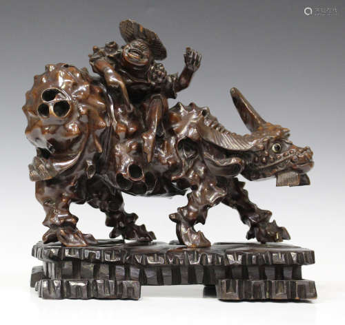 A Chinese carved gnarled hardwood figure group of a boy seated on the back of a water buffalo, early