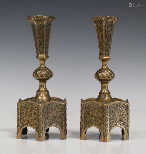 A pair of Persian brass candlesticks, probably late 19th century, of octagonal form, decorated in