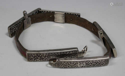 An Islamic white metal mounted leather belt, 19th century, each rectangular openwork panel cast