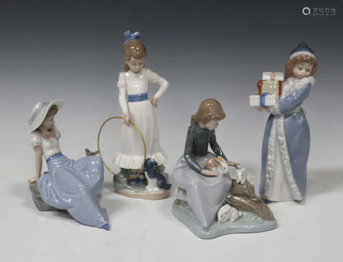 Four Nao porcelain figures, comprising Young Girl with Rabbits, Christmas Time, Listening to Bird