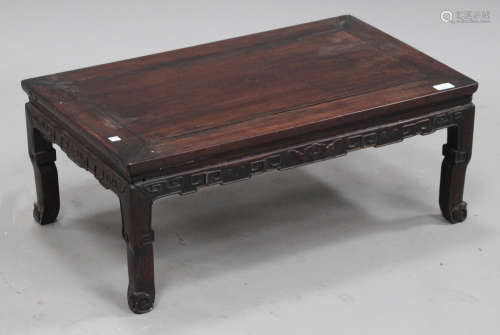 A Chinese hardwood low table, late Qing dynasty, with rectangular panelled top, the frieze carved in